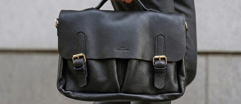 Black full-grain leather laptop bag, close up